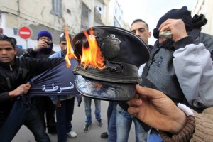 Rioters burn a policeman's hat during clashes with the police in downtown of the capital Tunis